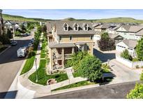 Beautiful multi-story home featuring brick accents, multiple balconies, landscaped yard, and inviting outdoor fire pit at 10241 Bellwether Ln, Lone Tree, CO 80124