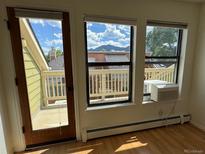 Bright living room with light wood floors, balcony access, and mountain views at 3025 Broadway St # 17, Boulder, CO 80304