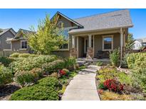 Charming home featuring a professionally landscaped front yard with colorful flowers and mature trees at 5419 Uinta St, Denver, CO 80238