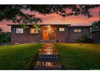 Charming brick home featuring a well-maintained lawn and inviting stone walkway at sunset at 6205 Pierce St, Arvada, CO 80003