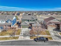 Two-story home featuring well-maintained lawn, mature trees, and a two-car garage, set against a backdrop of expansive sky at 23593 E Eads Dr, Aurora, CO 80016