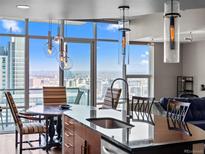 Bright kitchen featuring granite countertops, modern lighting, and expansive windows with city views at 891 14Th St # 3410, Denver, CO 80202