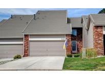 Charming home featuring a brick facade, a two-car garage, and a well-maintained front yard at 9403 Southern Hills Cir, Lone Tree, CO 80124