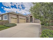 Charming brick home featuring a two-car garage, well-maintained lawn, and mature trees at 23808 E Bellewood Dr, Aurora, CO 80016