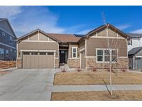 Charming single-story home featuring a two car garage, stone accents, and low maintenance landscaping at 741 Green Mountain Dr, Erie, CO 80516