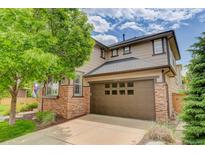 Two-story home featuring a brick and siding exterior, a two-car garage, and a well-maintained lawn at 3070 Redhaven Way, Highlands Ranch, CO 80126