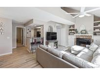 Bright living room features light wood floors, fireplace, and neutral color scheme for a modern, inviting space at 8331 S Upham Way # 101, Littleton, CO 80128