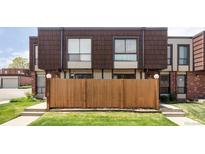Townhome exterior with a privacy fence and lush lawn in front, providing a cozy and inviting curb appeal at 9453 W Utah Pl, Lakewood, CO 80232
