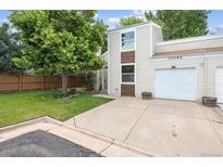 Charming exterior view of home with attached garage, green lawn, and mature shade tree at 15942 E Rice Pl # B, Aurora, CO 80015