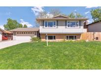 Well-maintained two-story home with a lush green front yard and attached garage at 3298 Quail St, Wheat Ridge, CO 80033