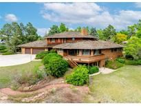 Unique, multi-story home featuring a wood and brick exterior, complemented by mature landscaping at 1961 S Xenia Ct, Denver, CO 80231