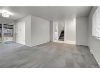 Spacious living room featuring neutral carpeting and access to the outdoor patio with an abundance of natural light at 6250 S Windermere St, Littleton, CO 80120