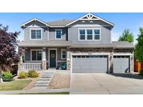 Charming two-story home with a well-manicured lawn, stone accents, and a three-car garage at 20529 E Brunswick Pl, Aurora, CO 80013