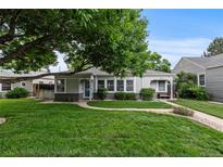 Charming home with a well-maintained front yard, mature tree, and inviting walkway at 2640 S Marion St # 2646, Denver, CO 80210