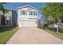 Charming two-story home with a well-maintained front yard and attached two-car garage at 9905 Aftonwood St, Highlands Ranch, CO 80126