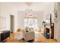 Bright living room with hardwood floors, fireplace, plush seating, and a decorative window at 2808 N Humboldt St, Denver, CO 80205