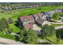 Two-story green home with a brown roof, lush lawn, and a golf course neighborhood at 23427 Song Bird Hills Pl, Parker, CO 80138