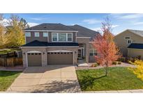 Two-story brick home with a three-car garage and landscaped yard at 11940 Silvertop Cir, Parker, CO 80134