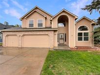 Charming two-story home featuring a two-car garage, well-maintained lawn, and inviting entrance at 584 W Prestwick Way, Castle Rock, CO 80104