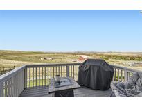 Enjoy the outdoors on this spacious deck with gray composite decking, a fire pit, and expansive rural views at 4746 River Highlands Loop, Elizabeth, CO 80107