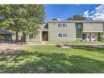 Inviting green townhome with a well-manicured lawn and mature trees at 940 S Peoria St, Aurora, CO 80012