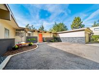 Charming single-story home boasting a well-maintained front yard, dark brick accents, and a welcoming orange front door at 4920 E Vassar Ln, Denver, CO 80222