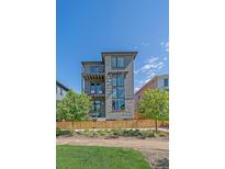 Modern home with stone accents, balconies, and a well-maintained front yard at 6047 N Nepal Ct, Aurora, CO 80019