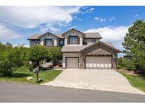 Charming two-story home with a three-car garage and well-manicured lawn, perfect for suburban living at 6299 Ellingwood Point Pl, Castle Rock, CO 80108