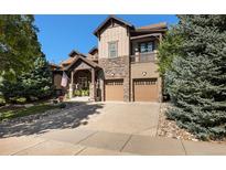 Beautiful home featuring a stone and siding exterior, two-car garage, and an inviting covered front porch at 24273 E Fremont Dr, Aurora, CO 80016