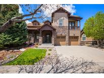 Charming two-story home featuring stone accents, a well-manicured lawn, and an attached two-car garage at 24273 E Fremont Dr, Aurora, CO 80016