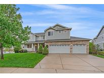 Beautiful two-story home featuring manicured lawn, stone accents, and a three-car garage at 6393 S Richfield St, Aurora, CO 80016