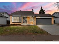 Charming single-story brick home with a well-maintained lawn and an attached two-car garage at 19417 E Purdue Cir, Aurora, CO 80013