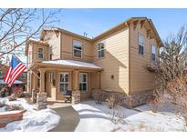 Two-story tan house with snow-covered walkway and landscaping at 3953 Blue Pine Cir, Highlands Ranch, CO 80126