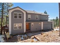 Charming two-story home with gray siding, arched windows, and a well-maintained front yard at 6904 Sprucedale Park Way, Evergreen, CO 80439