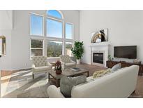 Bright living room boasts a fireplace, large windows with views and plush seating at 6904 Sprucedale Pkwy, Evergreen, CO 80439