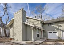 Exterior view showcasing the stucco siding, chimney, and attached garage of this lovely home at 9551 E Chenango Ave, Greenwood Village, CO 80111
