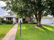 Charming single-story home with a well-manicured lawn and mature tree in front at 291 Magnolia St, Denver, CO 80220
