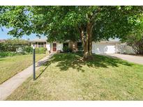 Charming single-story home with mature tree, lush lawn, and attached two car garage at 291 Magnolia St, Denver, CO 80220