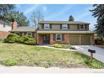 Charming two-story home with brick and siding exterior, a well-manicured lawn, and an attached two-car garage at 7376 S Jackson St, Centennial, CO 80122