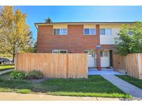 Charming brick townhome featuring a well-maintained lawn and a privacy fence at 8079 Wolff St # A, Westminster, CO 80031