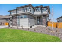 Modern two-story home featuring manicured lawn, stone accents, and large windows at 89 Clara Pl, Castle Pines, CO 80108