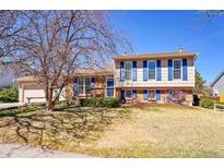 Charming two-story home with blue shutters and a spacious front yard at 1244 S Argonne Cir, Aurora, CO 80017