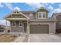 Charming two-story home featuring a two-car garage and a welcoming covered porch and beautifully landscaped front yard at 12921 E 108Th Way, Commerce City, CO 80022