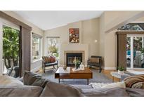 Inviting living room with fireplace, vaulted ceiling, and large windows at 150 Blue Spruce Ct, Highlands Ranch, CO 80126