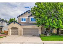 Charming two-story home with a three-car garage, landscaped yard, and welcoming front porch at 10472 Longleaf Dr, Parker, CO 80134