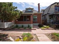 Charming brick home featuring a well-manicured lawn and inviting walkway at 132 Delaware St, Denver, CO 80223