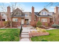 Attractive townhome featuring a well-maintained lawn, red brickwork, and inviting entrance at 443 Garfield St, Denver, CO 80206
