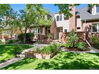 Charming two-story home featuring a manicured front lawn and attractive brick facade at 443 Garfield St, Denver, CO 80206