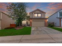 Charming two-story home boasts manicured lawn, brick accents and mature tree at 3186 W Indian Summer Ln, Castle Rock, CO 80109
