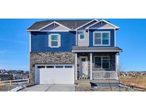 Charming two-story home with blue siding, stone accents, a two-car garage and covered front porch at 758 N Clubview St, Watkins, CO 80137
